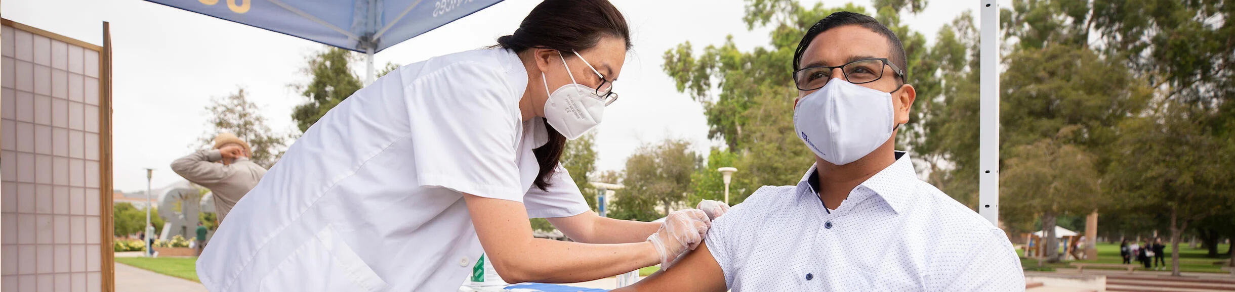 Woman giving a vaccine shot to a patient